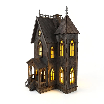 Svietiaci drevený gotický domček vyrezávaný laserom s teplým žltým svetlom v oknách ako halloweenska dekorácia